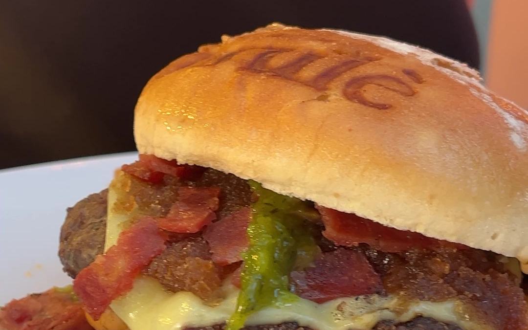 Hamburguesa artesanal Brulè con pan marcado, tocineta, queso fundido y chorizo